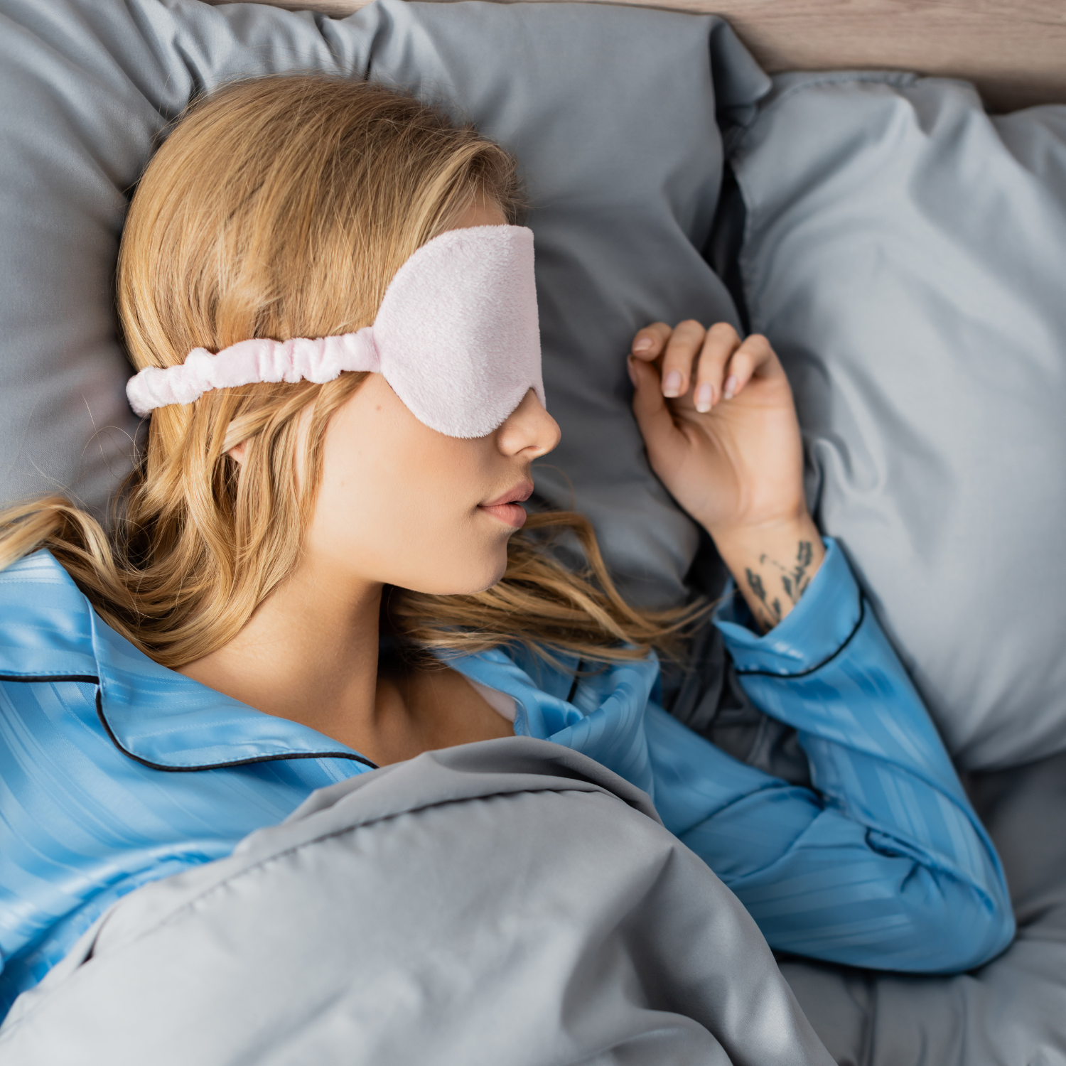 Woman laying in a bed wearing a sleep mask - Sleep Horizon